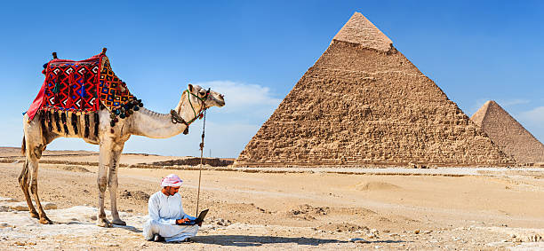 beduíno usando um computador portátil ao lado da pirâmide - pyramid of mycerinus imagens e fotografias de stock