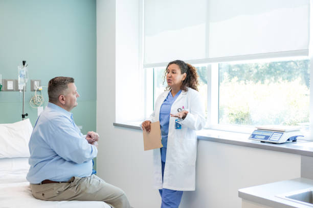istock Female surgeon gestures while talking to the male patient about his procedure 1818651311