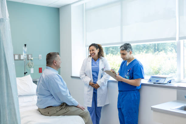 istock Male nurse makes notes while the female doctor talks with the patient 1818651319