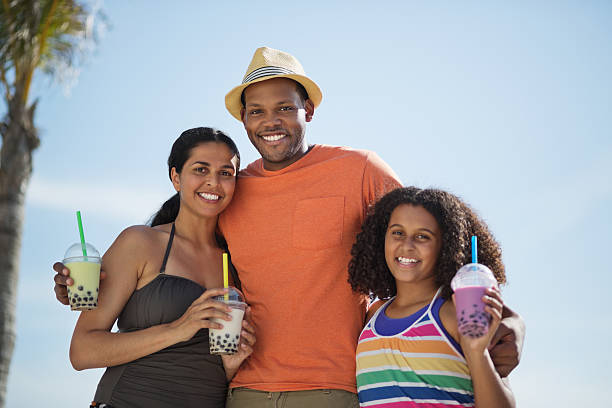 istock Family With Bubble Teas Standing Against Clear Sky 181865564