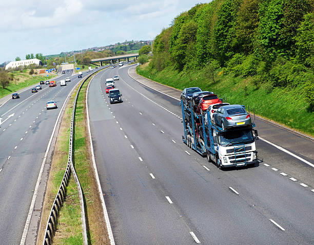 Car Transporter on UK Motorway A car transporter delivering new vehicles to a showroom in the UK auto shipping stock pictures, royalty-free photos & images