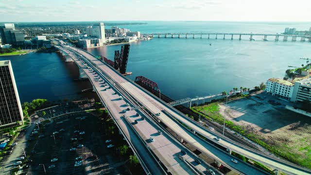 Massive transportation bridge with afternoon traffic mainly one side out of the city stand still river pool water various vehicles city vibe atmosphere sunny in Acosta Bridge, Jacksonville, Florida