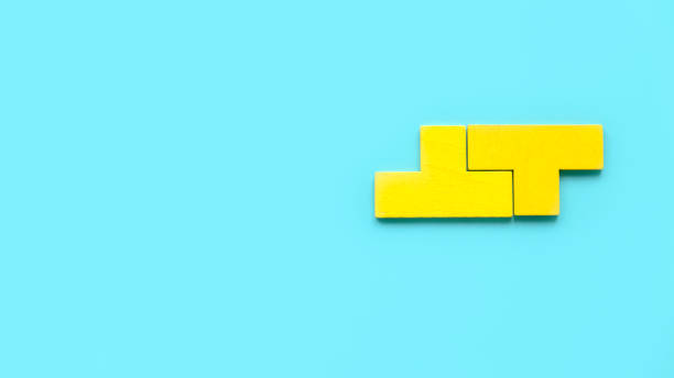 istock Top view two piece of yellow puzzle isolated on a blue background with copy space. 1818658943
