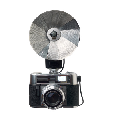 Old fashioned range finder film camera and flash on white background