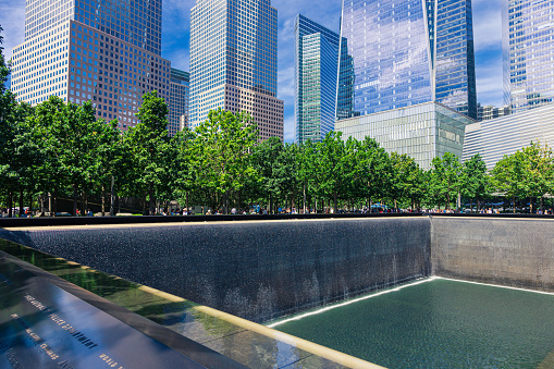 World Trade Center Towers, World Financial Center Towers, Pool with Waterfall of the 9/11 Memorial and Blue Sky in Background. The Pool is where the Footprints of the Twin Towers were and is Free for Public Viewing, New York City, NY, USA. 3:2 Image Aspect Ratio. Canon EOS 6D (full frame sensor) DSLR and Canon EF 24-105mm F/4L IS lens.