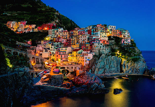 Beautiful view of Manarola at night "Manarola, Cinque Terre, ItalyA bit noise added for the real film effect." riverbank photos stock pictures, royalty-free photos & images