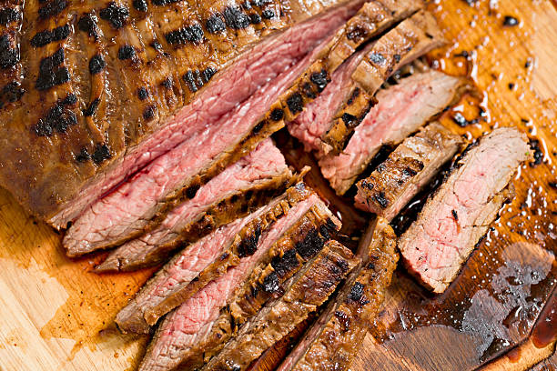 Flank Steak "An overhead extreme close up shot of a juicy, grilled and partially sliced flank steak intended for Mexican fajitas." flank steak stock pictures, royalty-free photos & images