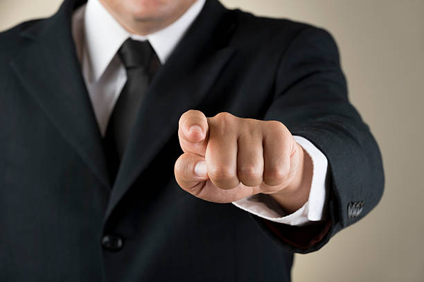 istock man in black suit and tie pointing at camera no head 181866636