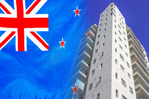 Modern residential building on background of flag New Zealand. New apartment building on background of flag New Zealand. Realty concept and home buying or new apartment in New Zealand