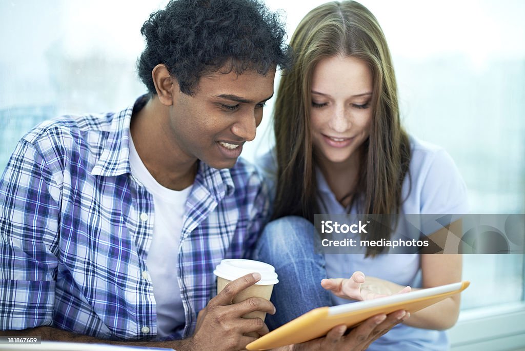 Using tablet pc Smiling couple using digital tablet together 20-24 Years Stock Photo