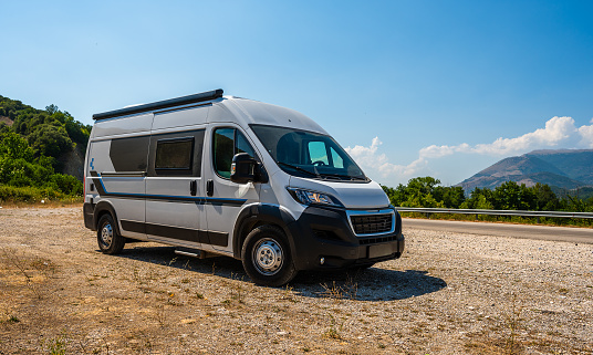 Campervan, Motorhome RV parked on the side of the road, Meteora, Greece. Travelers with camper van are resting on an active family vacation on a road trip in Greece.