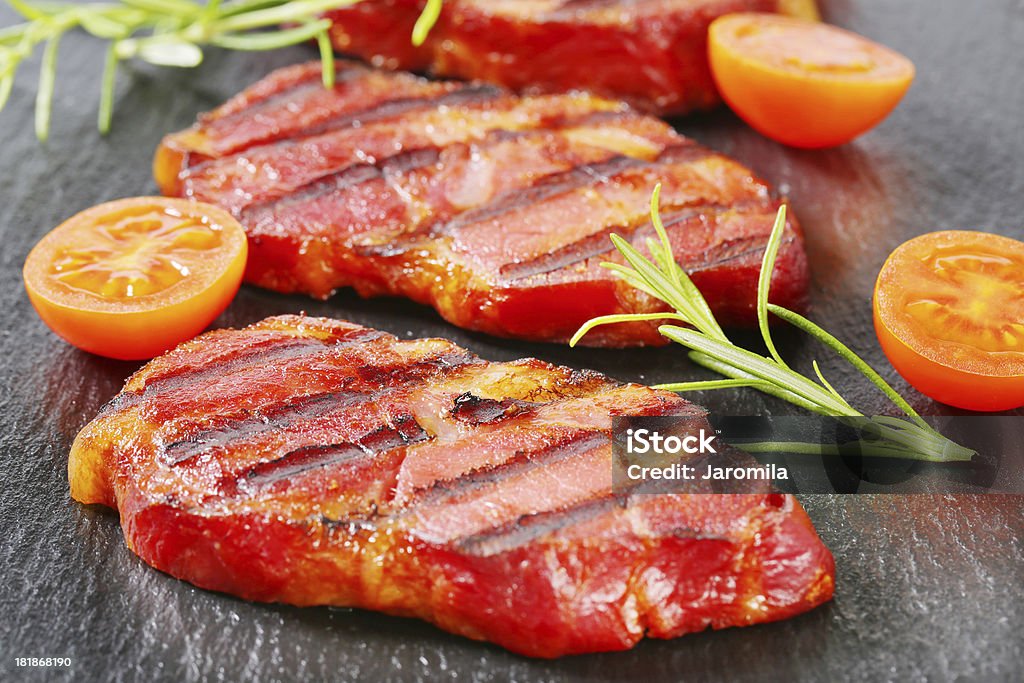 Fatias de carne suína grelhado pescoço em um fundo preto - Foto de stock de Alecrim royalty-free