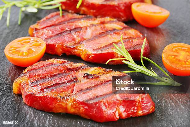 Foto de Fatias De Carne Suína Grelhado Pescoço Em Um Fundo Preto e mais fotos de stock de Alecrim