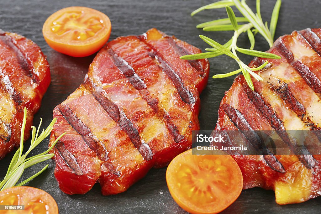 Tranches de porc grillé au cou, sur un fond noir - Photo de Aliment en portion libre de droits