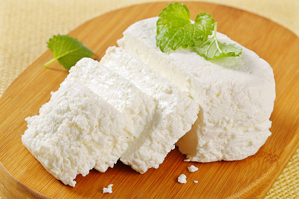 sliced ricotta cheese sliced ricotta cheese with a fresh mint on a wooden cutting board cottage cheese photos stock pictures, royalty-free photos & images
