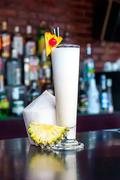 Photo of Pina Colada cocktail near on the  classic black bar table