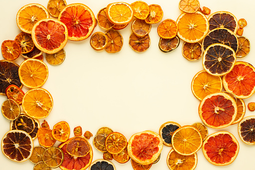 Dried citrus fruits frame, sliced orange and tangerine, lime and lemon, kumquat and grapefruit slices , preparation for the celebration of Christmas