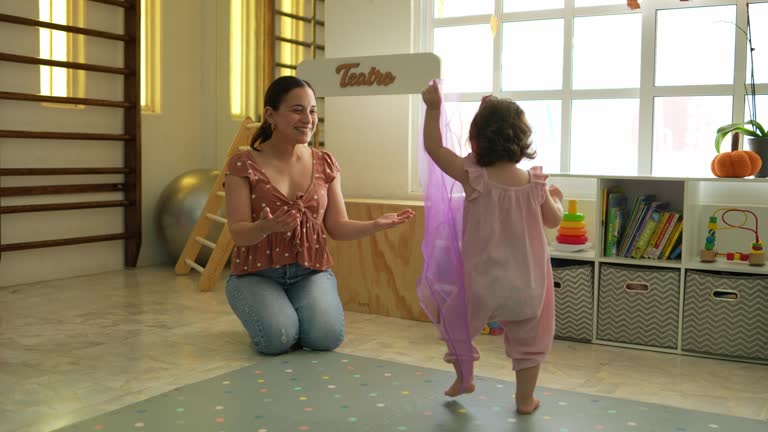 Mid adult mother playing with her daughter in the playroom