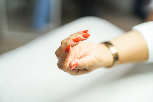 Woman applying nail polish to her nails at the beauty center