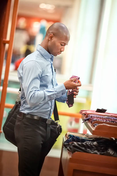 Ties of shade and colorful tones with strict design pattern are folded in row in the window of fashionable mens clothing store