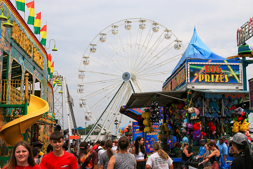 Columbus, Ohio, USA - 5 August 2023: A Vibrant Carnival Atmosphere with Throngs of People Enjoying Rides, Games, and Delicious Treats.