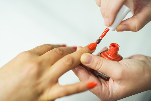 close-up woman applying nail polish to her nails