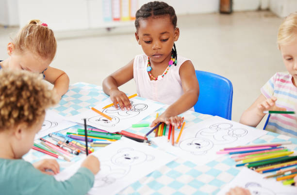 istock Black kid, pencil and drawing for homework in classroom with creative, art or project for picture. Little girl, serious look and choice of color for learning, education or development of motor skills 1818697683
