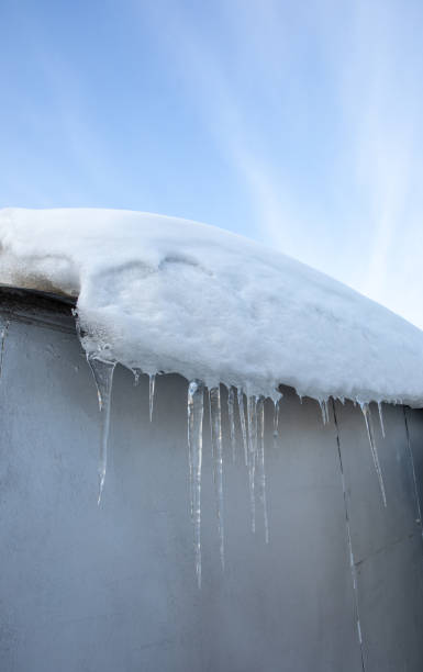 istock Icicles hanging from the roof, blue sky. Thaw outside. 1818698281