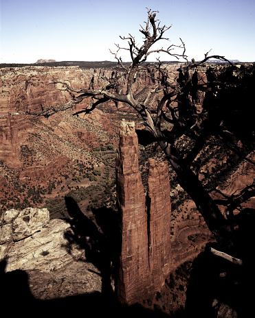 Sandstone spire rising from a canyon floor , Spider Rock in 750 tall.  It is named for Spider Woman. through stories taught the people how to weave.