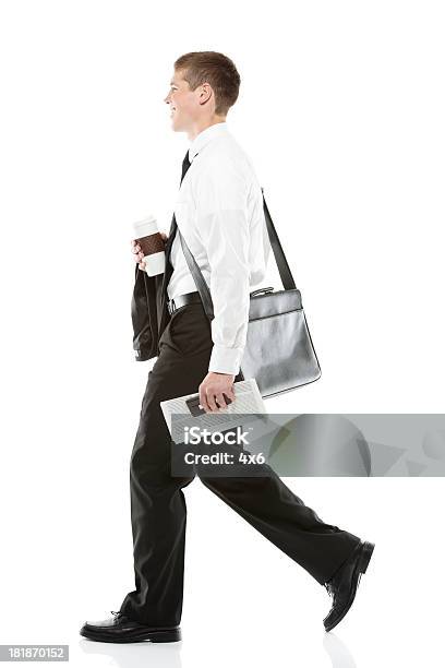 Side View Of A Businessman Walking Stock Photo - Download Image Now - Carrying, Men, Newspaper