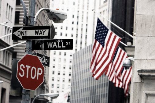The Wall Street sign and row of American flags outside the New York Stock Exchange.