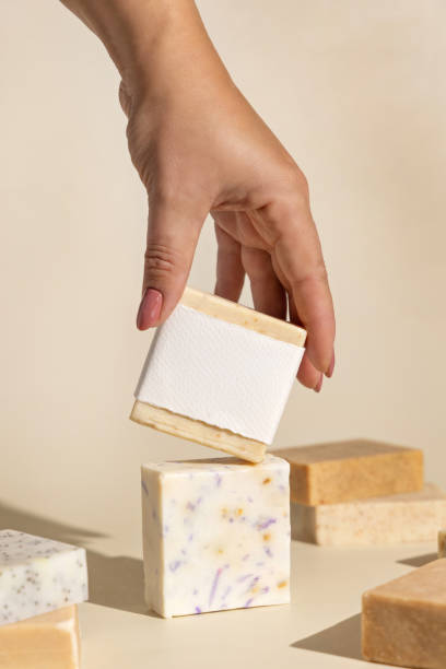 istock Hand keeps natural beige soap bars with blank label on light beige, hard shadows 1818711634