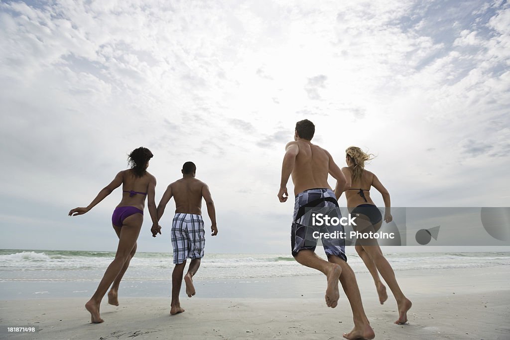 Multi-étnica amigos correndo na praia - Foto de stock de Calção royalty-free