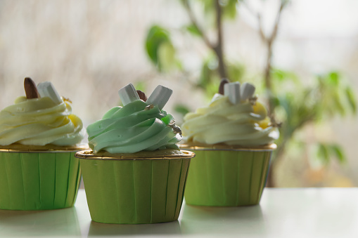 Chocolate cupcake with creamy pistachio and lemon glaze on a light background. Template for displaying product presentation