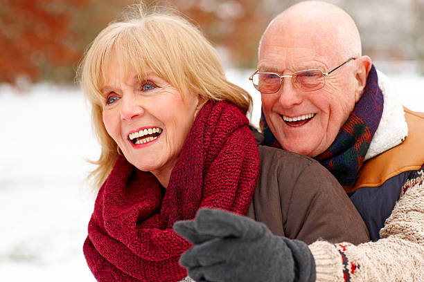 istock Smiling elderly man and his wife in snow park 181871880