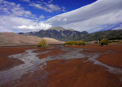 Great Sand Dunes contains large sand dunes as tall as 750 ft. Spring and early summer the  Medano Creek can creat surge waves that come down out of the mountains from the melting snow.