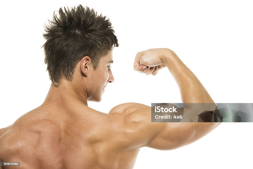 Vista posteriore dell'uomo muscoloso flettendo il bicipite - Foto stock royalty-free di A petto nudo