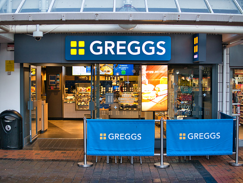 The frontage of a branch of British bakery chain Greggs. It specialises in savoury products such as pies, sausage rolls and sandwiches.