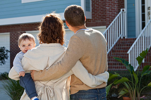 istock Young family looking at house 181873503