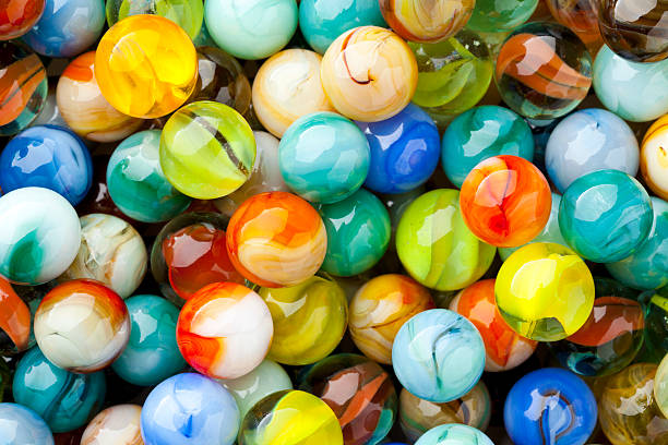 background, full frame close-up of marbles. - knikkers fotos stockfoto's en -beelden