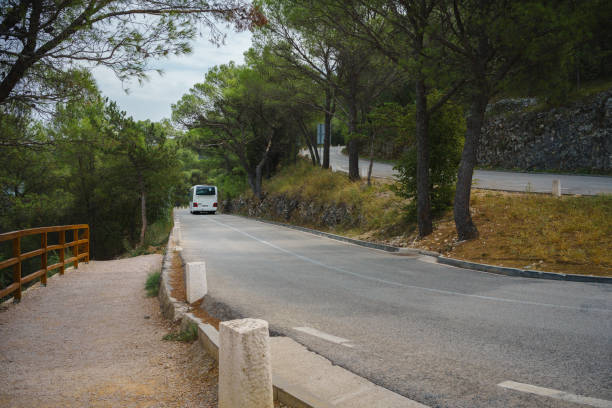 bus touristique blanc roulant sur une route de montagne sinueuse - car winding road highway autumn photos et images de collection