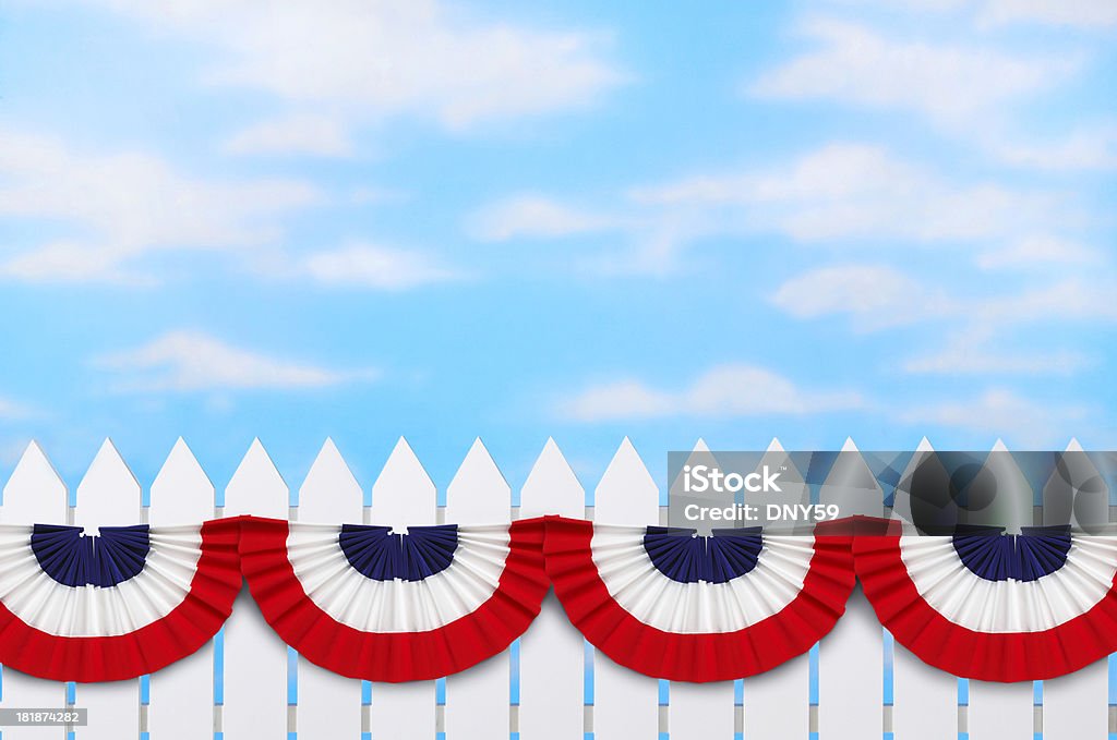 Fourth of July Bunting Red,white and blue bunting on a white picket fence. Picket Fence Stock Photo