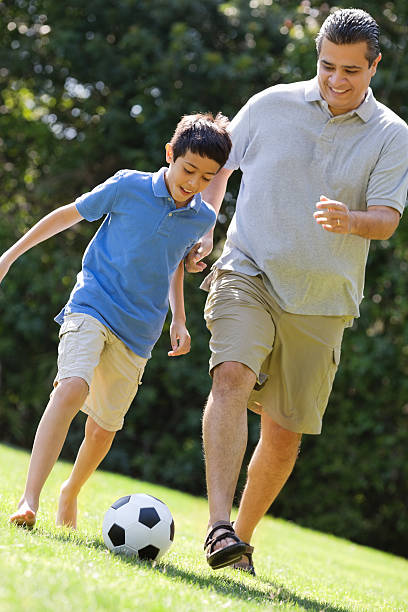 istock Father And Son Playing Soccer 181874297