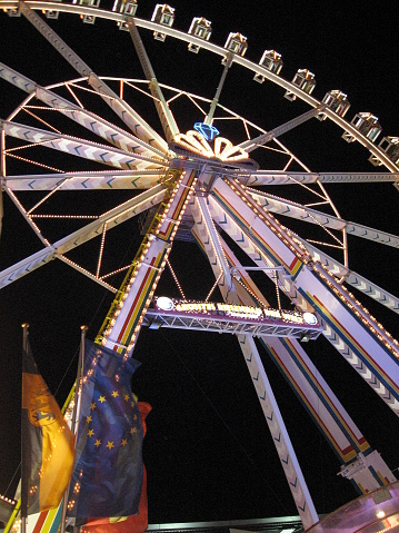 An illuminated Ferris wheel at night as seen during the Freimarkt in Bremen. The Freimarkt, meaning free fair is held every year in Bremen and is the oldest fair in Germany.