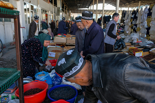 Istaravshan, Tajikistan - November 26, 2023: People buying raisins and dried fruits at the Istaravshan Central Market, Tajikistan.