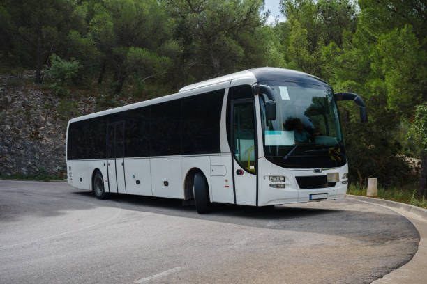 White tourist bus going around tight hairpin turn in a mountain road