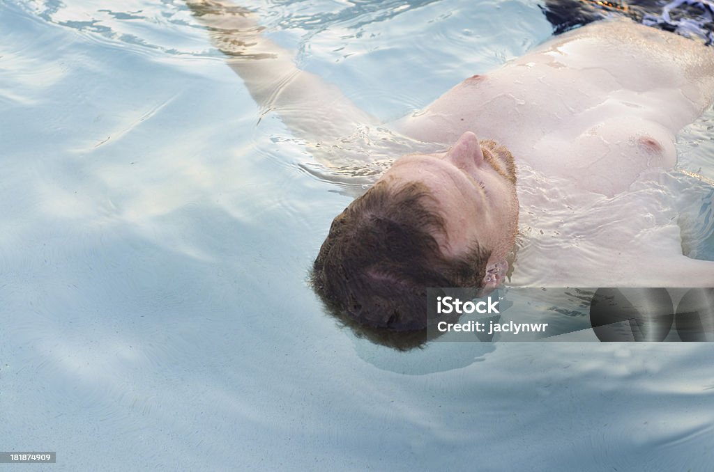 Hombre flota en el agua relajante en la piscina - Foto de stock de Actividades recreativas libre de derechos