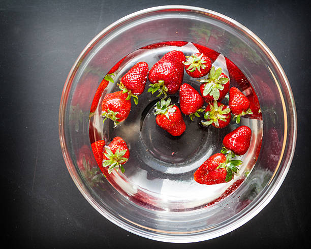 erdbeeren in eine schüssel mit wasser - washing fruit preparing food strawberry stock-fotos und bilder