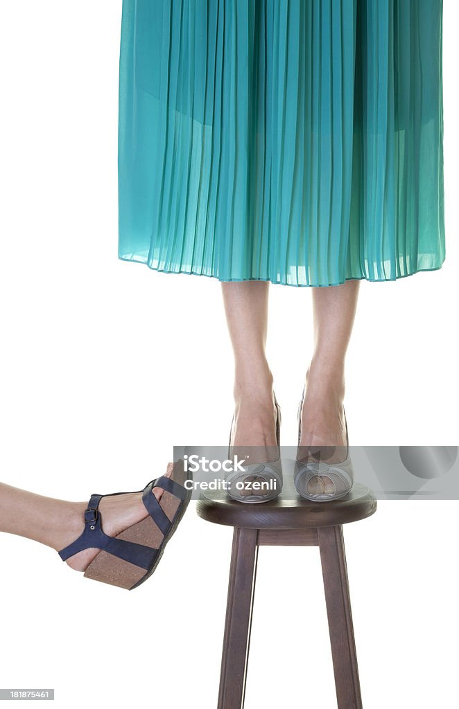 Assistance One woman standing on a stool while another one is going to push it over Anger Stock Photo