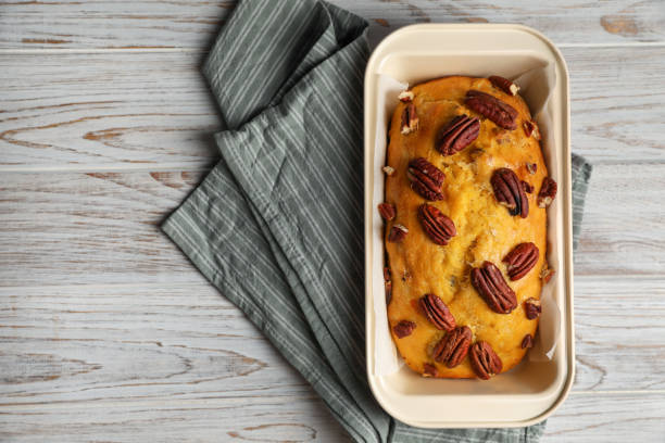 delizioso pane alla zucca con noci pecan su tavolo in legno chiaro, vista dall'alto. spazio per il testo - healthy eating cake halloween seed foto e immagini stock